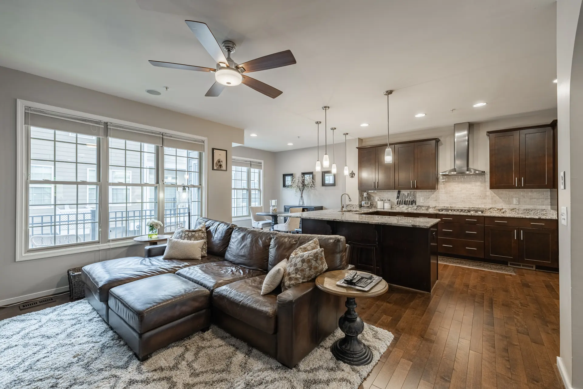 Open great room with leather sectional flowing into the kitchen