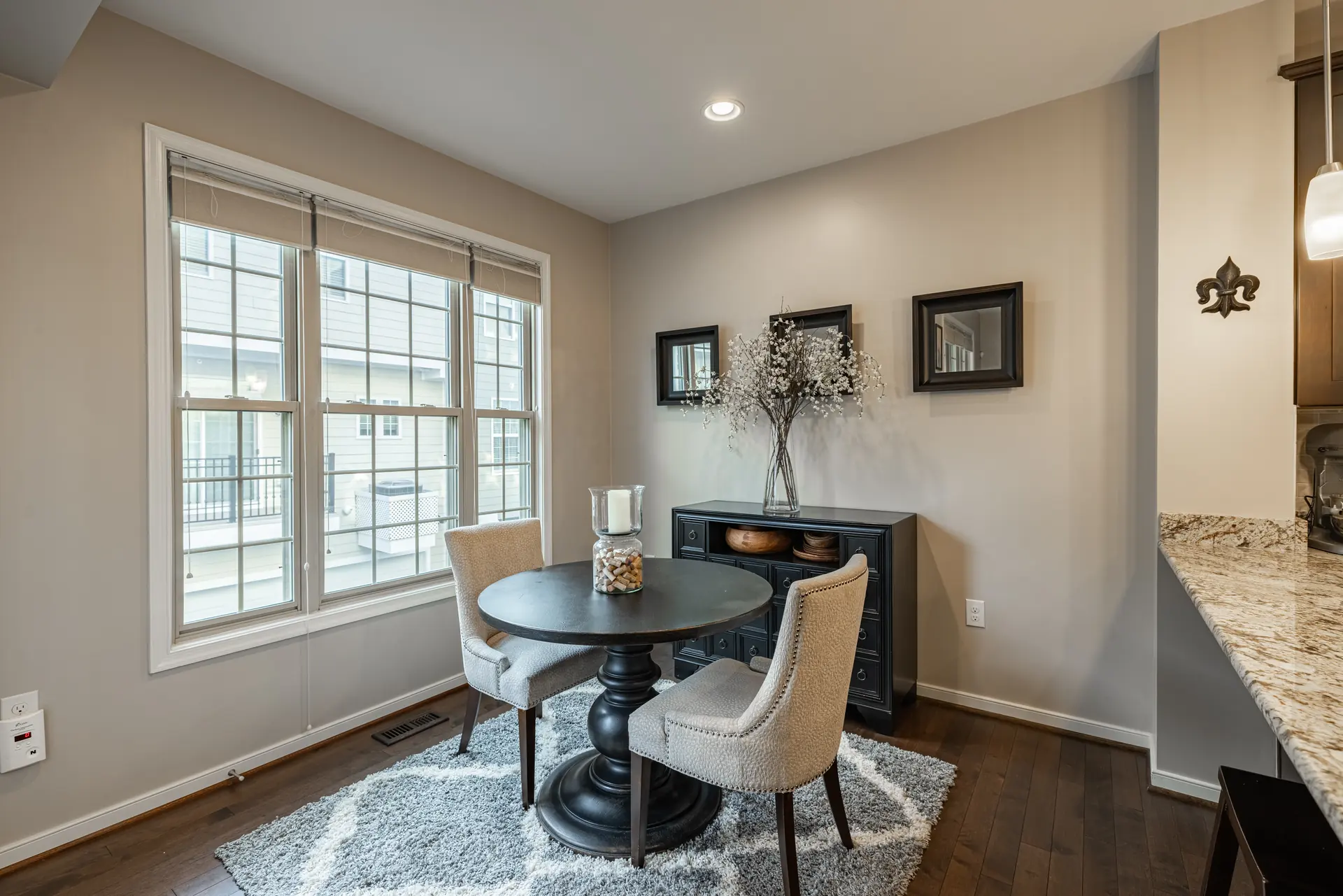 Breakfast nook with a round table beside tall windows