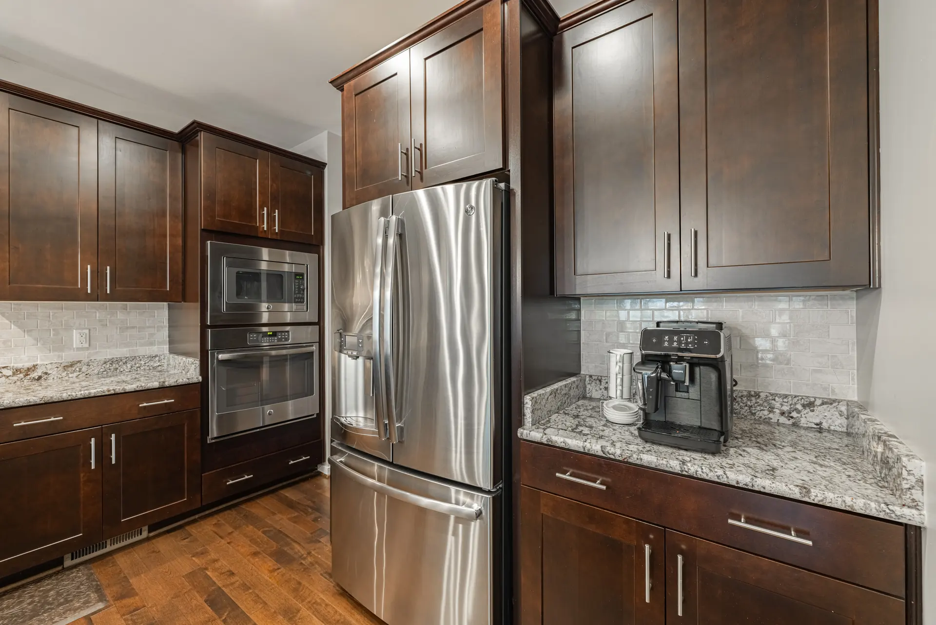 Stainless refrigerator, wall ovens and espresso cabinetry