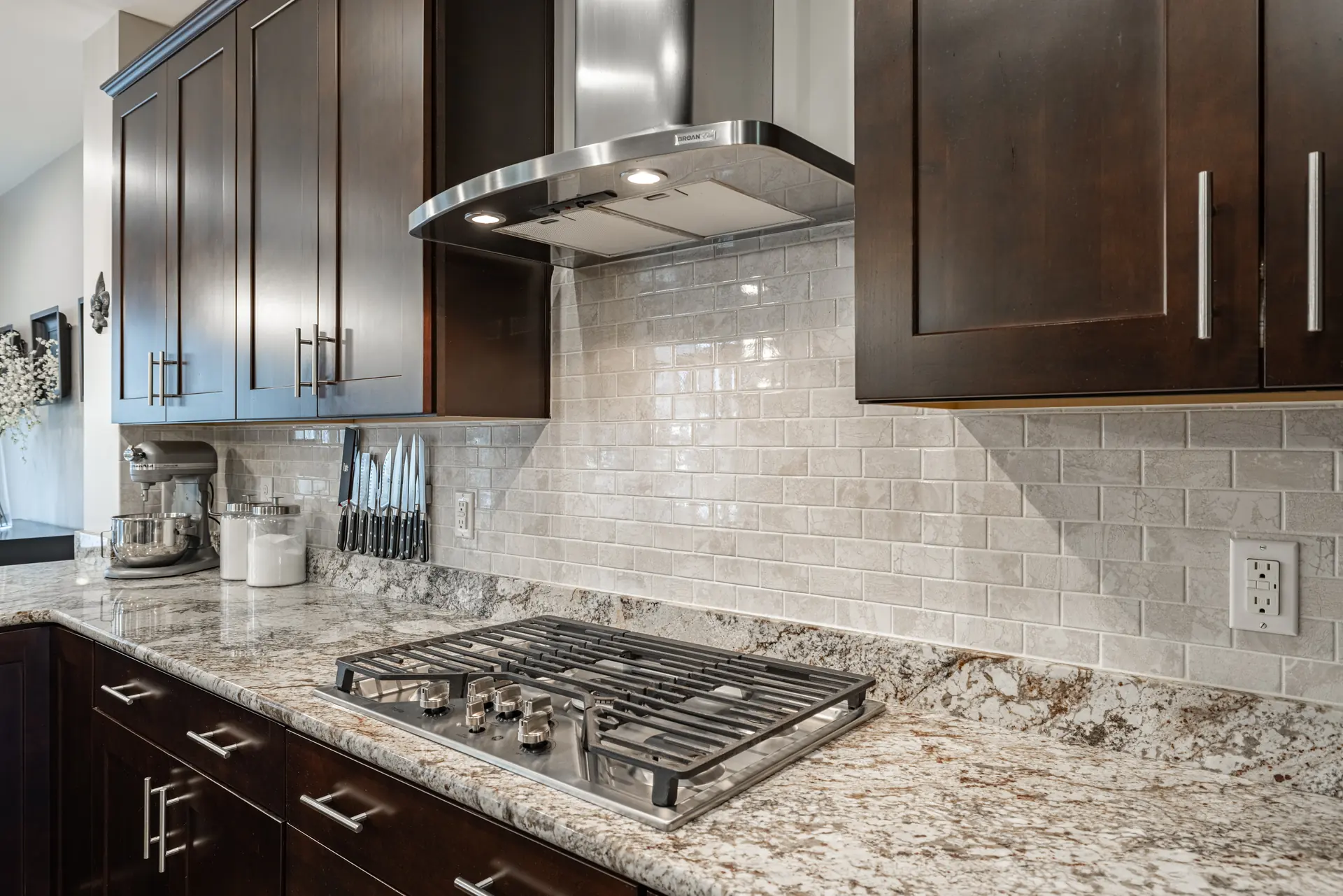 Gas cooktop with stainless hood and tile backsplash