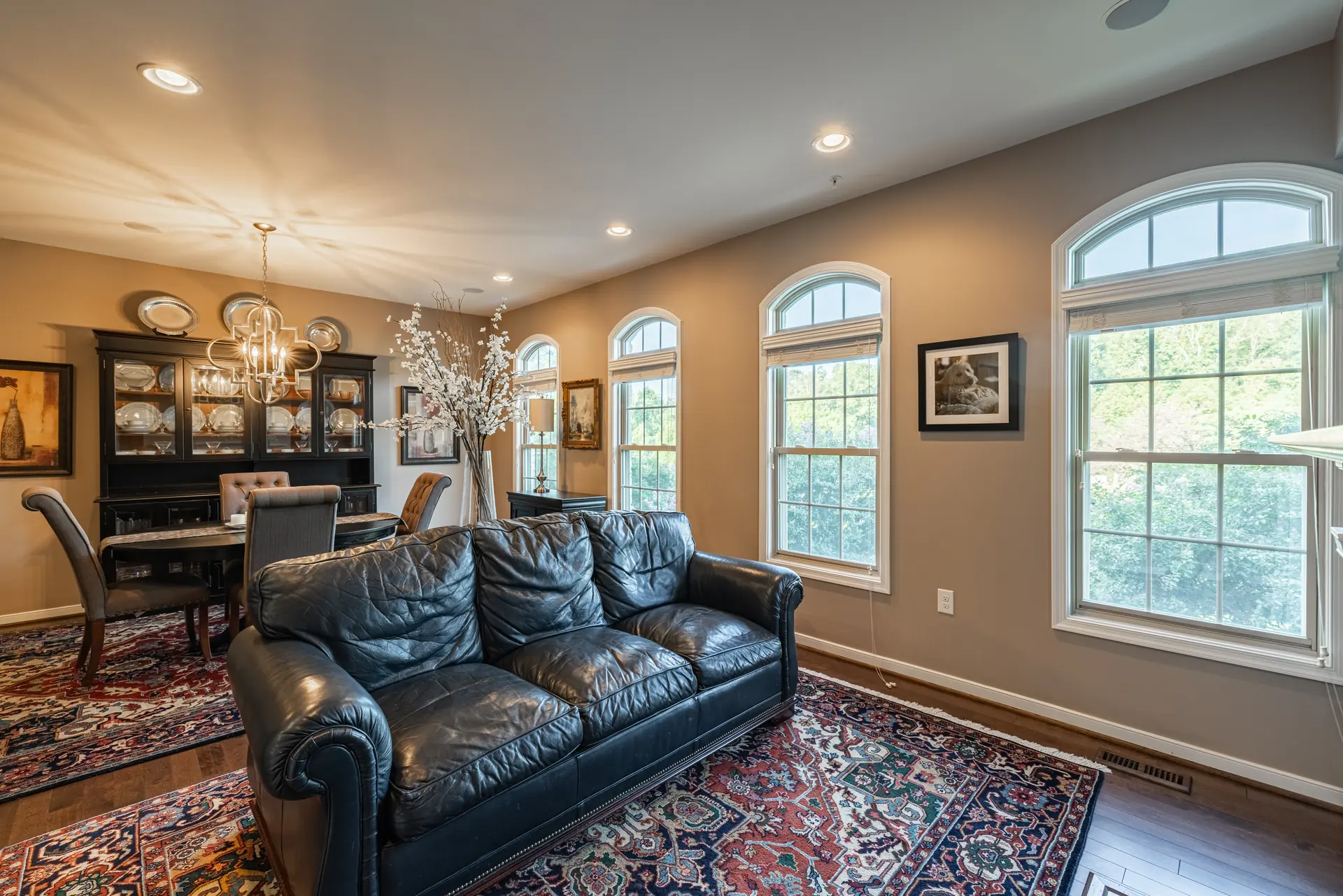 Sitting room and dining room beneath a row of arched windows