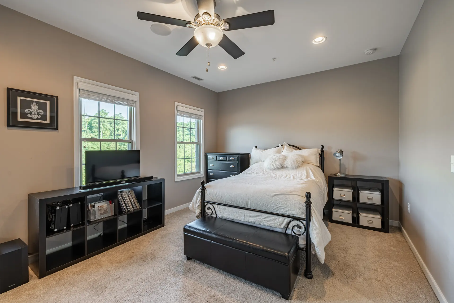 Bedroom with iron bed, bench and media console