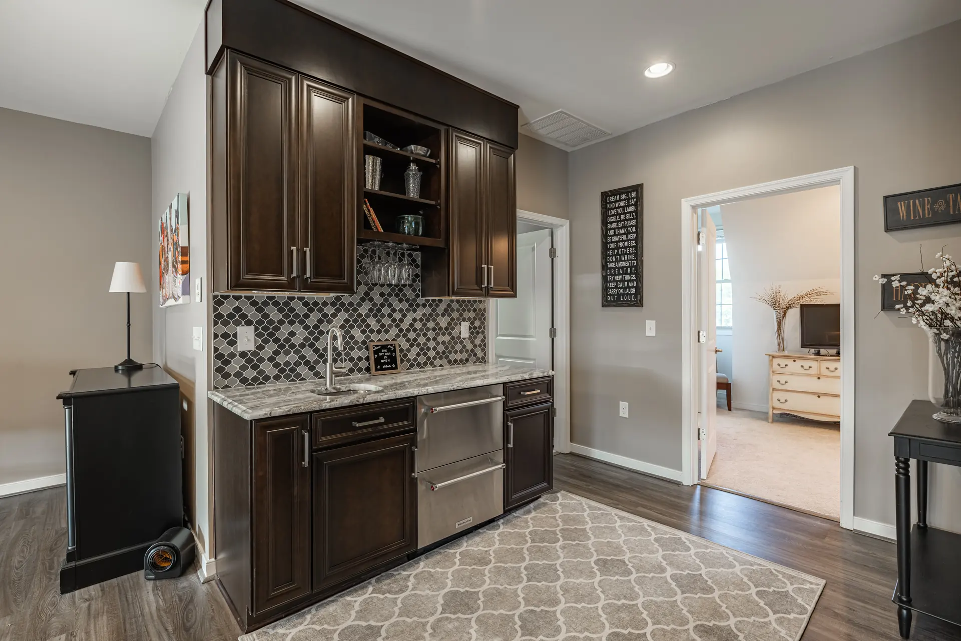 Wet bar with espresso cabinetry and mosaic tile backsplash