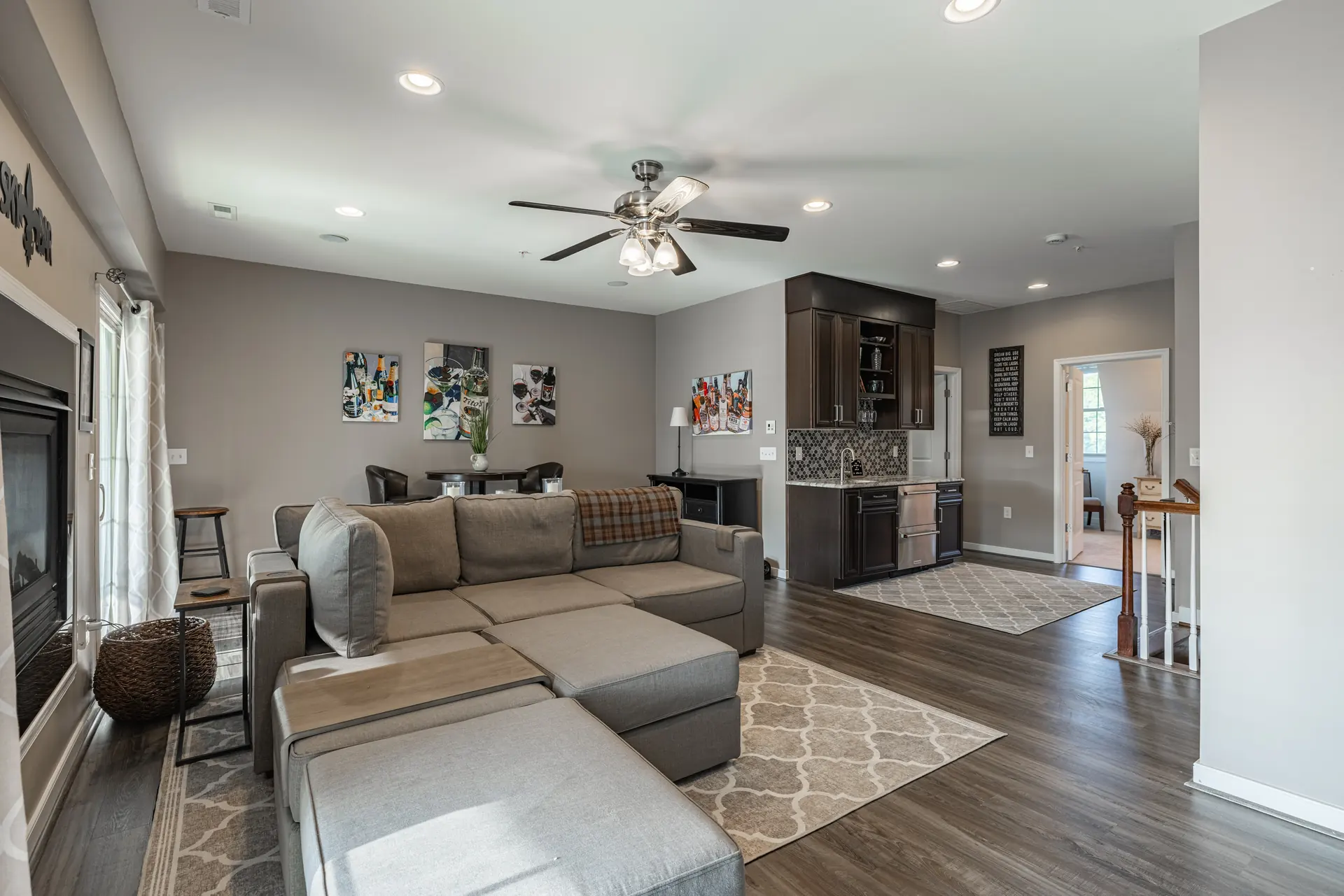Wide view of the upper-level living room and wet bar