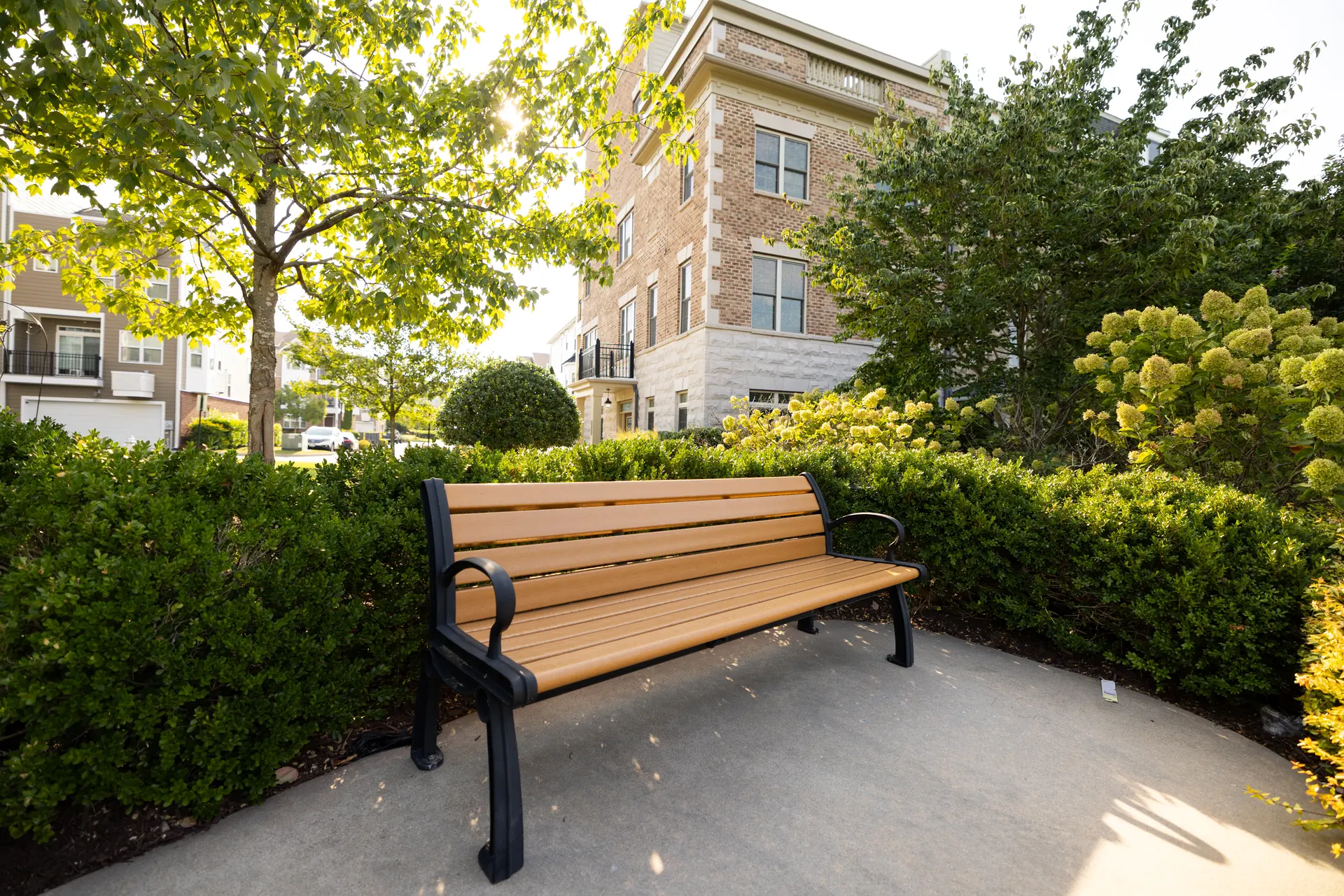 Bench in a landscaped seating nook near the townhomes