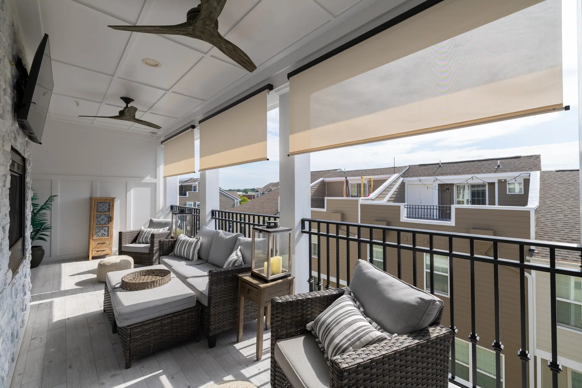 Covered rooftop porch with lounge seating and motorized shades