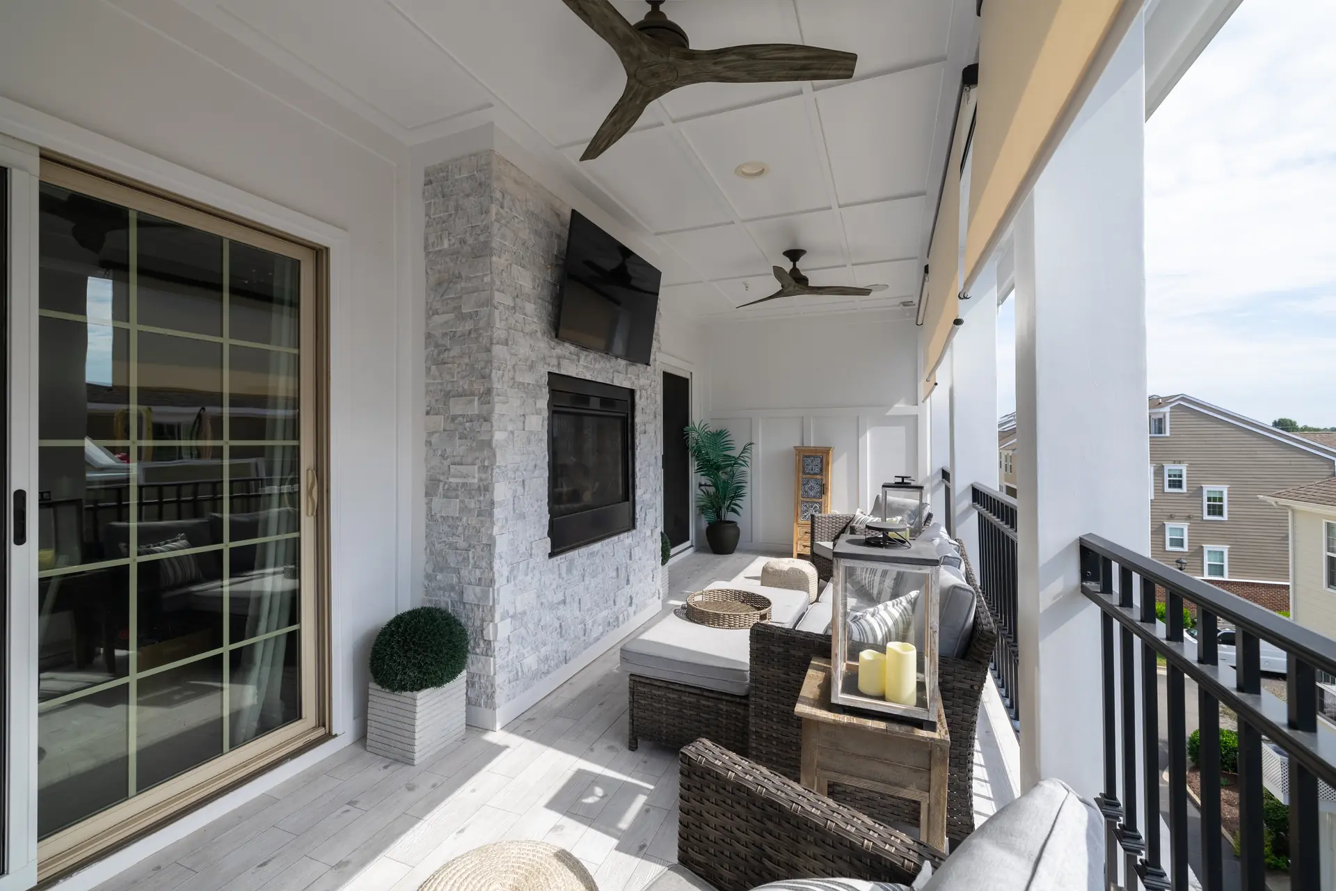 Covered rooftop porch with stone two-sided fireplace and mounted television