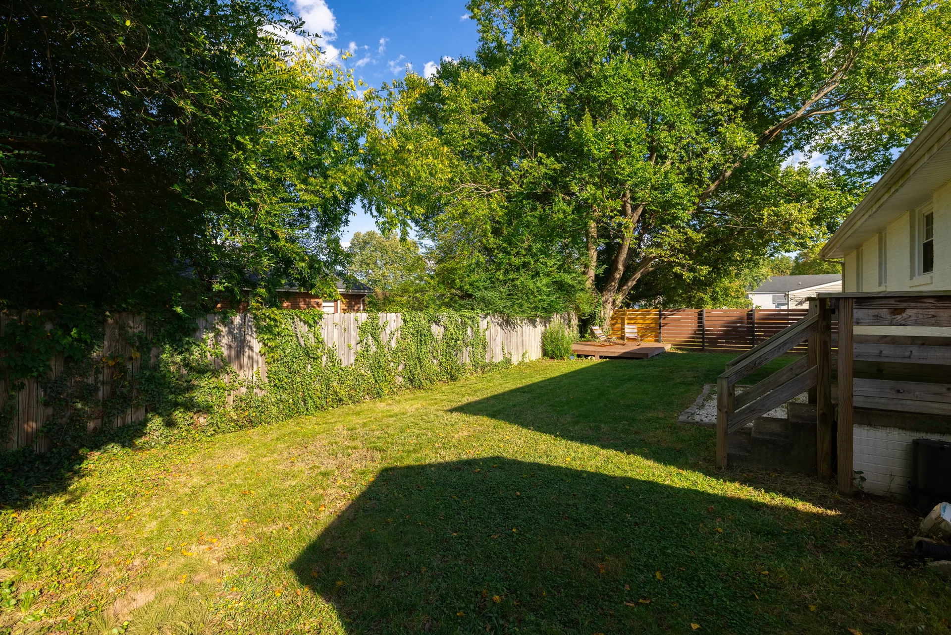 5312 Marian St &mdash; back garden with the wooden steps up to the back door