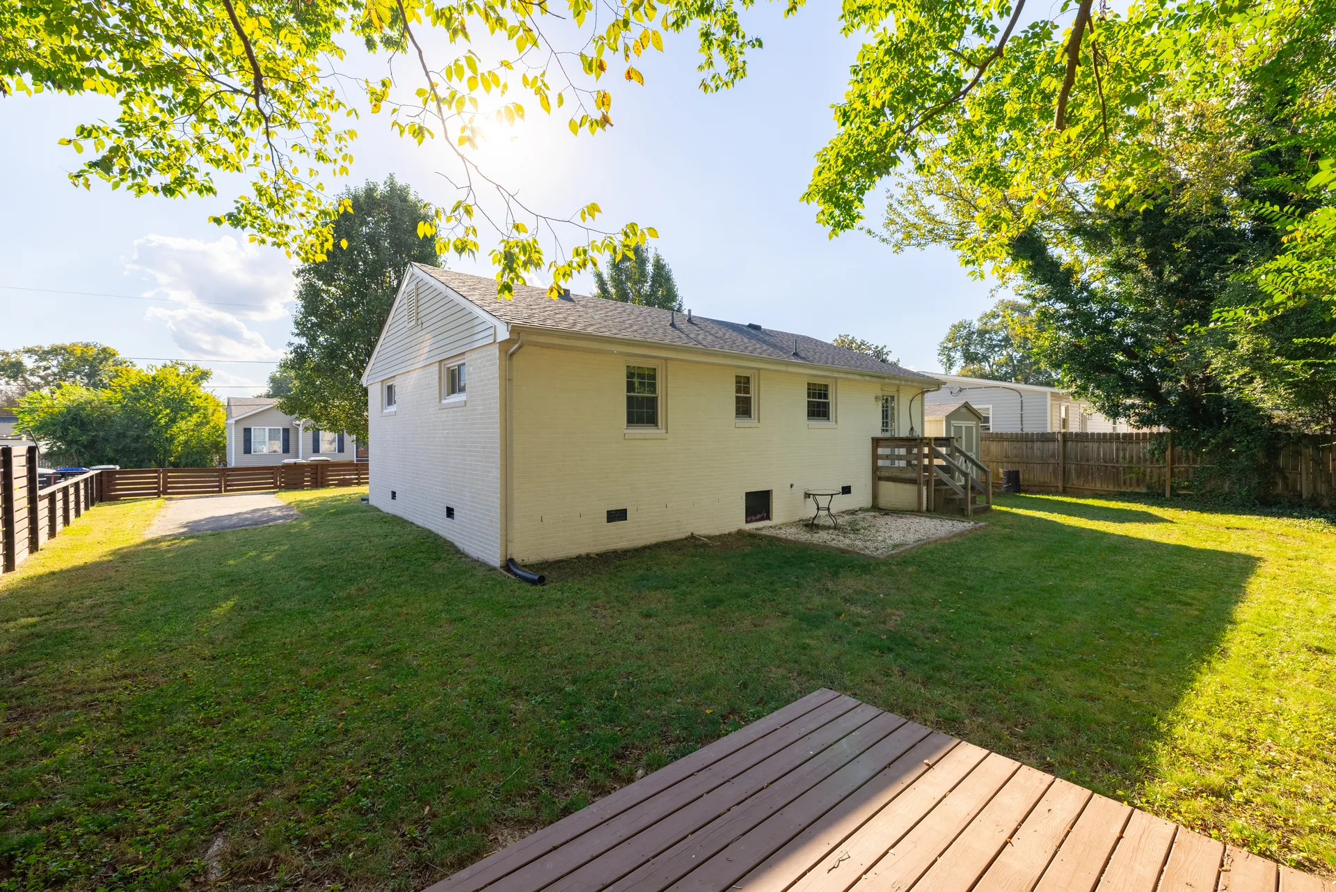 5312 Marian St &mdash; back garden with a wood deck, lawn and mature trees