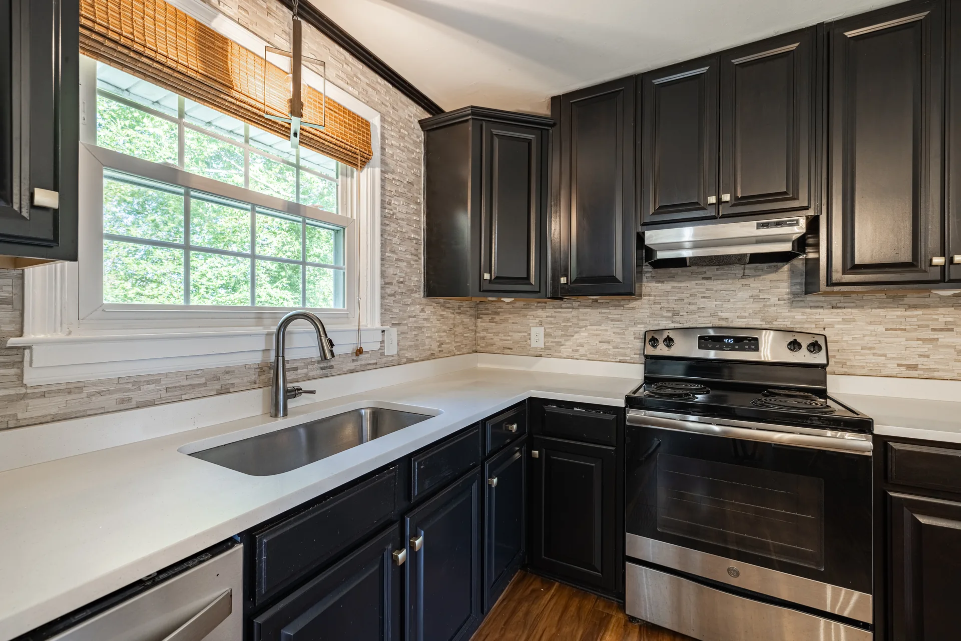 5312 Marian St &mdash; kitchen with quartz counters, a deep stainless sink, stone backsplash and a stainless range