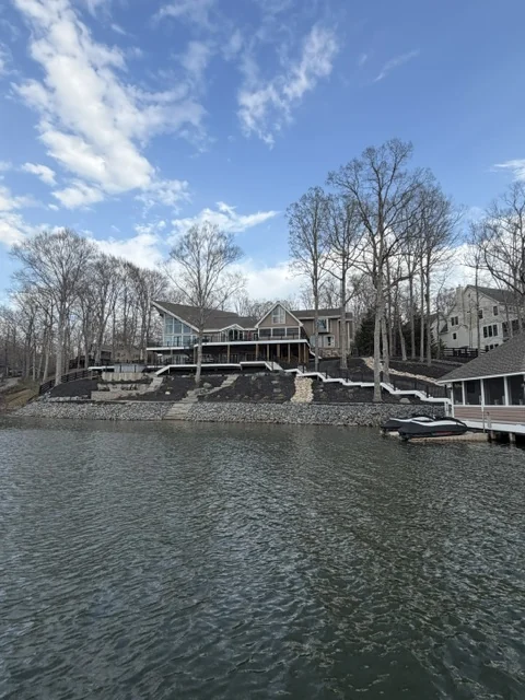 Lake Anna shoreline with terraced waterfront homes, a boat lift and open water in Lake Anna, Virginia